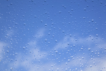 rain drops on window pane and blue sky