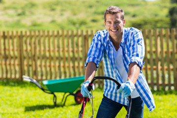 happy man mowing lawn - obrazy, fototapety, plakaty