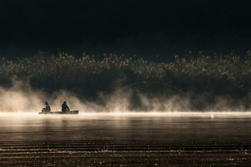 Boat of fisher men in a foggy lake