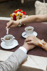 Coffee cups and holding hands and putting suger in coffe