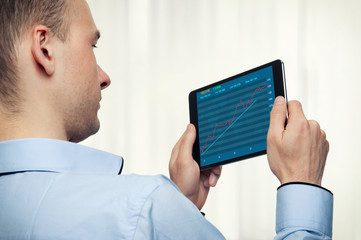 Man Holding Digital Tablet with stock market diagram