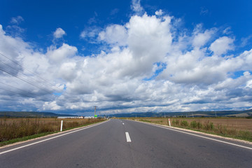 Fototapeta premium A country highway under a bright blue sky.