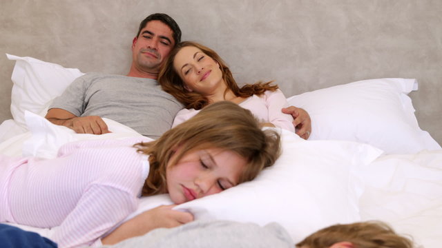 Cute parents and children lying on bed sleeping