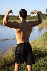 male bodybuilder model back view. outdoors