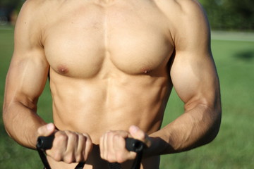 Fototapeta na wymiar muscular super-high level man pulls rubber bands