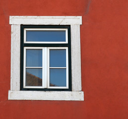Fototapeta na wymiar Old wooden window in the bright red wall