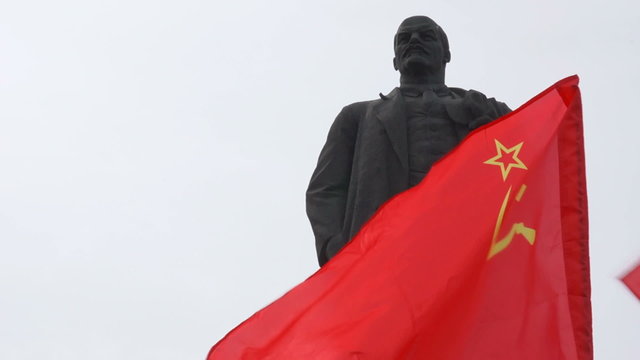 Monument to Vladimir Lenin end soviet flag flying.
