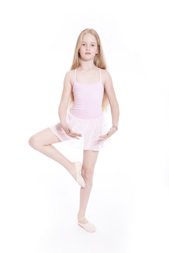 young girl dancing in pink ballet suit in studio