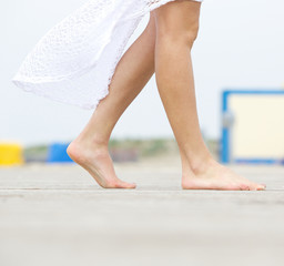 Young woman walking barefoot outdoors