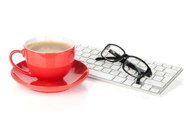 Red coffee cup, glasses and computer keyboard