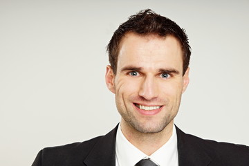 Smiling businessman in suit, left you can write some text