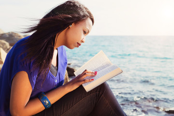 Young Girl Studying Her Bible By The Sea