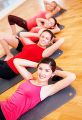 Fototapeta na wymiar group of smiling women exercising in the gym