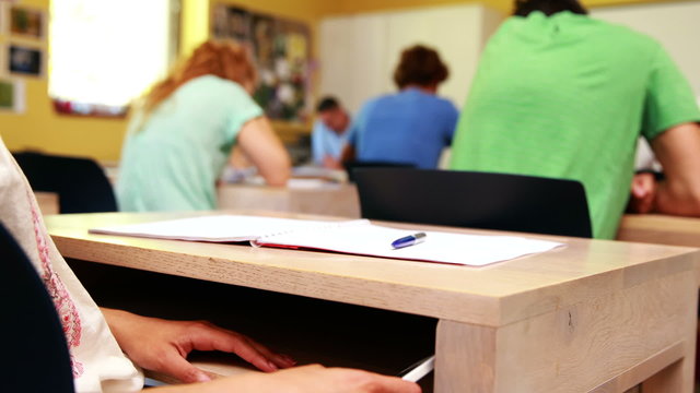 Student texting under the desk in clas