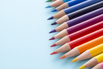 水色の背景にカラフルな色鉛筆