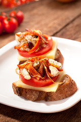 bread seasoned with oil and sliced tomatoes on a table