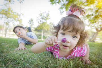 Cute Baby Girl and Brother with Lollipops in Park