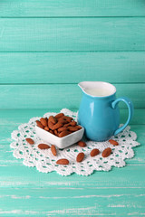 Almond milk in jug with almonds in bowl,