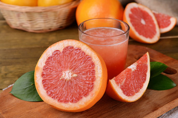 Ripe grapefruit with juice on table close-up