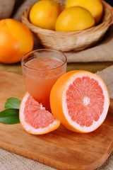 Ripe grapefruit with juice on table close-up