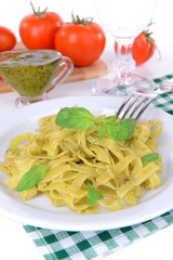Delicious pasta with pesto on plate on table close-up