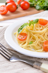 Delicious spaghetti with tomatoes on plate on table close-up