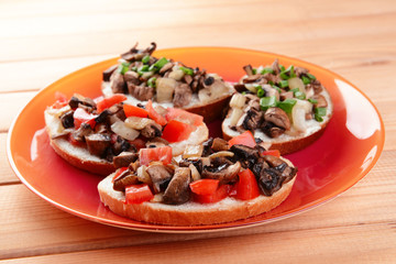 Delicious bruschetta with mushrooms on plate on table close-up