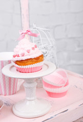 Tasty cup cake with cream on wooden chair