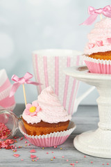 Tasty cup cakes with cream on grey wooden table