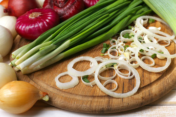 Different raw onion on wooden background