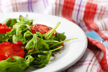 Green salad made with  arugula, tomatoes and sesame