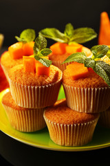 Tasty pumpkin muffins on dark background