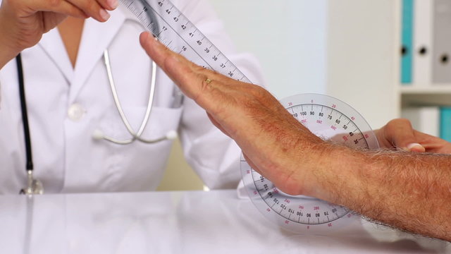 Doctor measuring patients wrist with goniometer