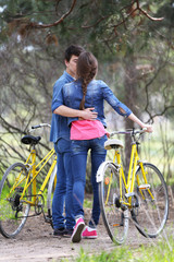 Obraz premium Young couple with bicycles in park