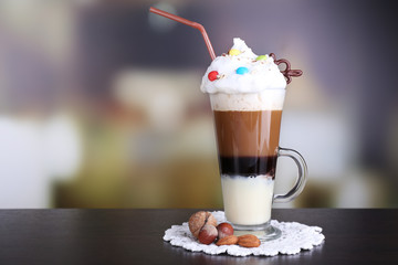 Glass of coffee on color wooden table, on dark background