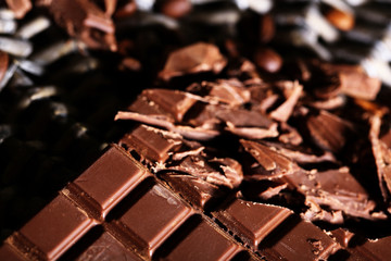 Chopped bar of chocolate on wicker mat background