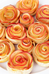 Fototapeta premium Tasty puff pastry with apple shaped roses on plate close-up