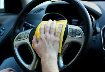 Hand with microfiber cloth polishing car