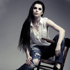 beautiful brunette, sitting on a brown wooden chair