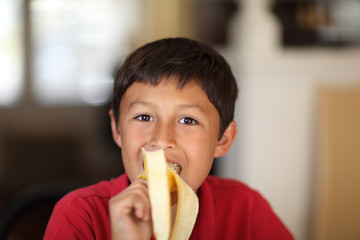 Young boy eating a banana