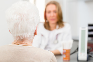 Doktor behandelt Seniorin in Arztpraxis