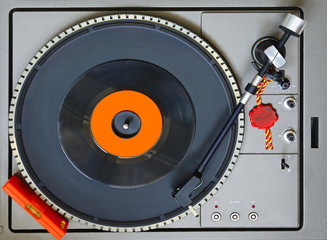 Top view of a turntable with level bubble and a 45 RPM vinyl