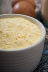 Corn flour on wooden background close up