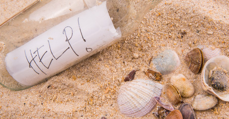 Concept image of a messge HELP in a bottle