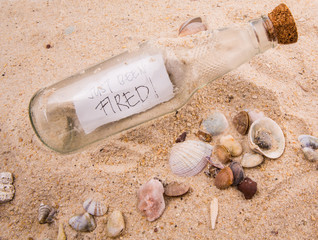 Concept image of a message JUST BEEN FIRED in a bottle