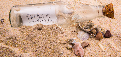 Concept image of a message BELIEVE in a bottle