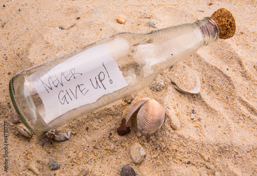 "Concept image of a message NEVER GIVE UP in a bottle" Fotos de archivo