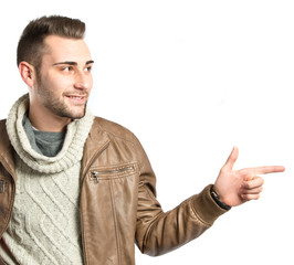Fototapeta premium Young man pointing to his right over white background
