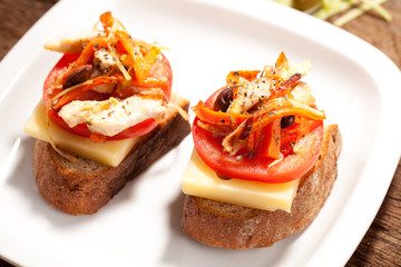Sandwich with tomato on a table with meat, tomato and olives