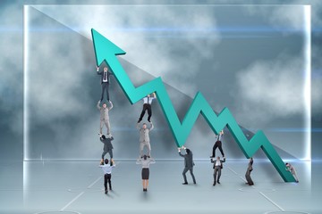 Composite image of business team holding up arrow